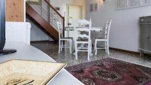 Ein Essbereich mit Tisch und Stühlen, eine Treppe und eine Wandleuchte.