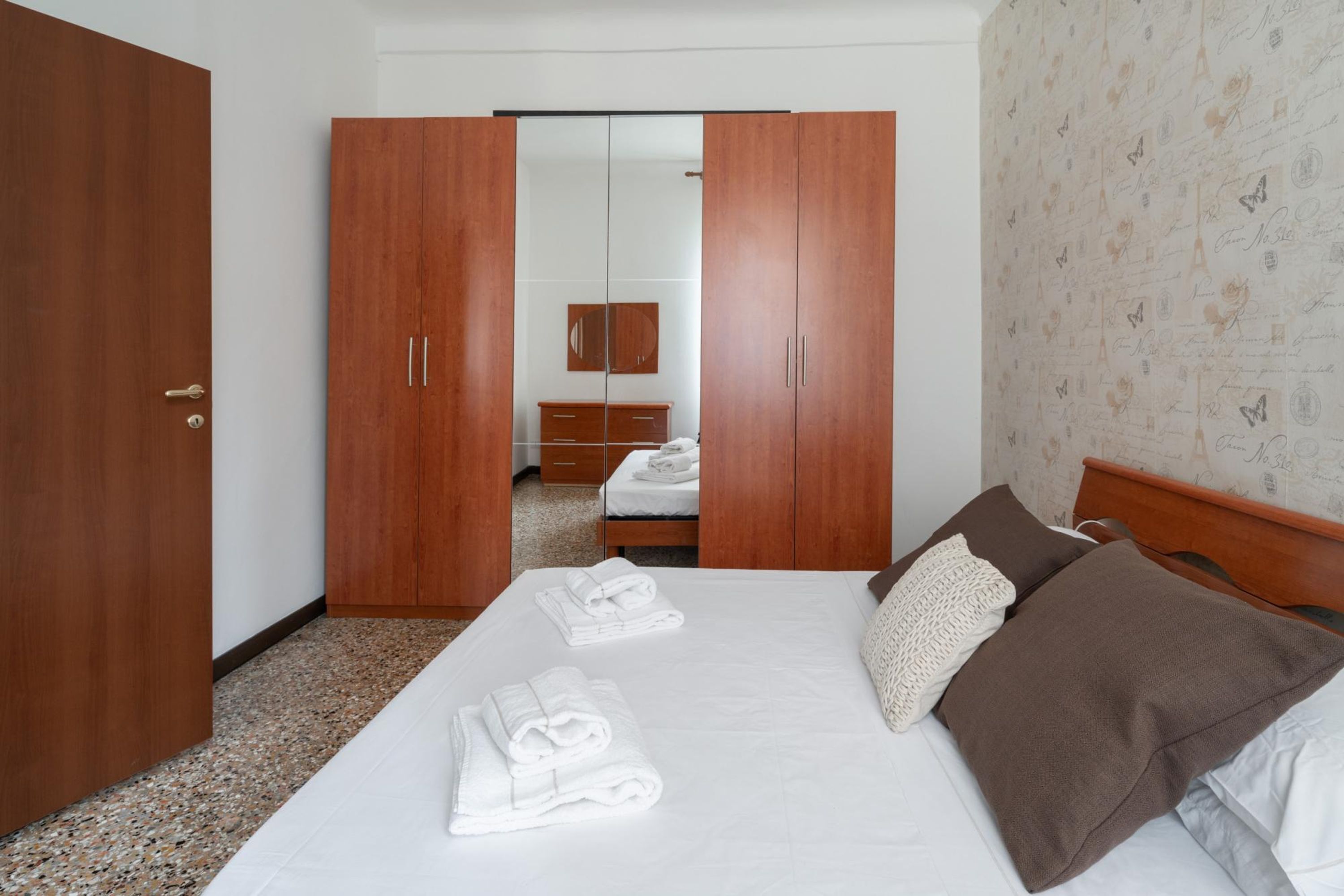 Een hotelkamer met een bed, een kledingkast en een spiegel.
