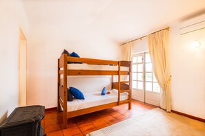 A bunk bed with two pillows, a small table, and a window with curtains. - Peaceful retreat w/ heatable pool, Portimão (Portimão)