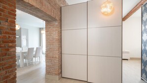 Une pièce moderne avec un mur en briques, une grande porte coulissante et un coin repas à l’arrière-plan.
