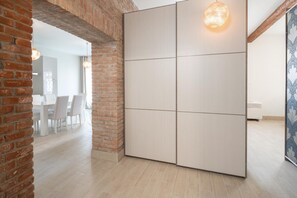 Een moderne kamer met een bakstenen muur, een grote schuifdeur en een eethoek op de achtergrond.