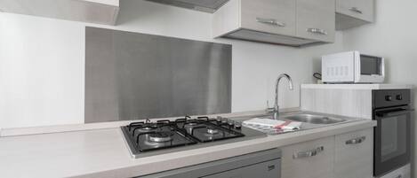 Une cuisine moderne équipée d’appareils électroménagers en acier inoxydable, d’un four à micro-ondes et d’un lave-vaisselle.
