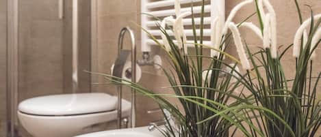 A bathroom with a toilet, sink, and a wooden planter with green plants.