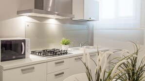 Una cucina moderna con forno a microonde, piano cottura e lavandino.