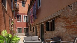 Un patio con mobiliario exterior y un muro de ladrillo.