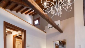 Un salón moderno con un sofá blanco, sillas grises, una mesa blanca y techo de madera.