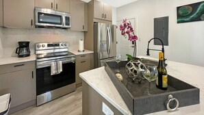 A modern kitchen with stainless steel appliances, a built-in oven, and a coffee maker. - Capitol Hill Scenic Unit with Bright City Views (Washington)
