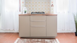 A compact kitchen with a gas stove, a small countertop, and a cabinet with drawers. - San Marco Penthouse by Wonderful Italy (Venice)