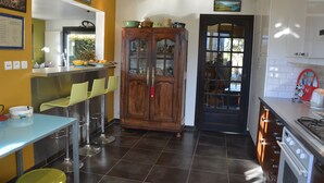 Una cocina con comedor, un armario con puertas de vidrio y una estufa.