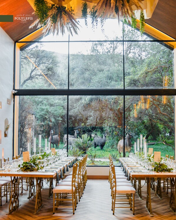 Un amplio comedor interior con ventanas grandes que dan a un paisaje natural.
