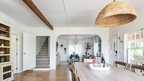 A spacious kitchen with a wooden table and chairs, a hanging light fixture, and a staircase leading to another room. - Farmhouse on wine scenic route, alpacas and hot tub. Pet friendly.  (Hillsboro)