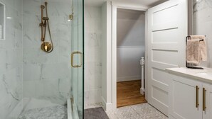 A modern bathroom with a glass-enclosed shower, white marble tiles, and a wooden floor. - Farmhouse on wine scenic route, alpacas and hot tub. Pet friendly.  (Hillsboro)