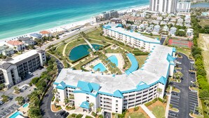 Un complexe hôtelier doté d’une piscine centrale, de plusieurs bâtiments et offrant une vue sur la plage.