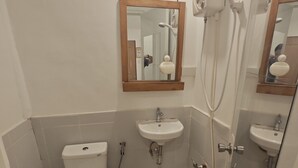 A compact bathroom with a toilet, two sinks, and a shower. - Room-Cola Inn (San Juan)