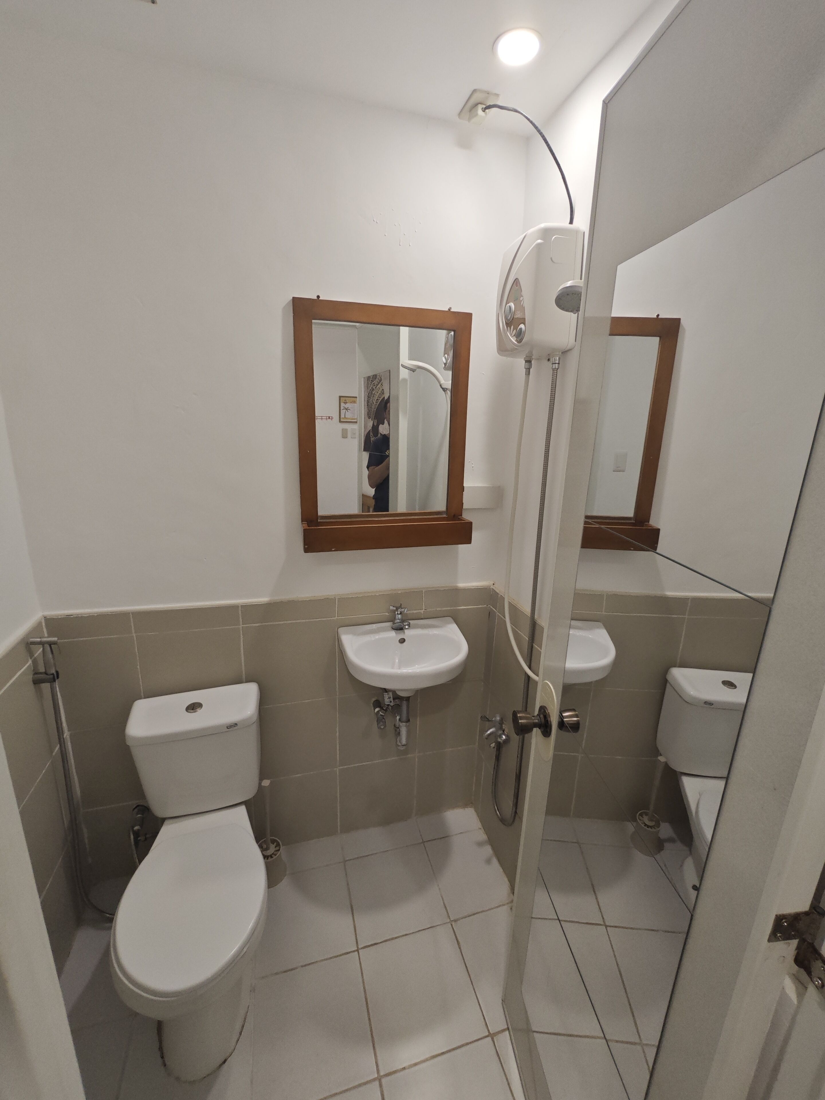 A bathroom with two toilets, a sink, and a shower.