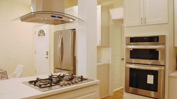 A kitchen with a gas stove, stainless steel appliances, and white cabinetry. - Spacious 5BR/5BA Group Stay w/Game Room + Parking, Sleeps 12, Central Location (Pittsburgh)