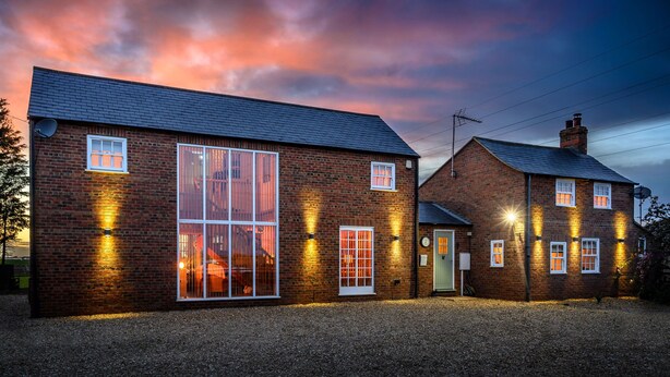 A two-story brick house with large windows and a gravel driveway. - French Vintage Cottage in the Heart of the Fens (Spalding)