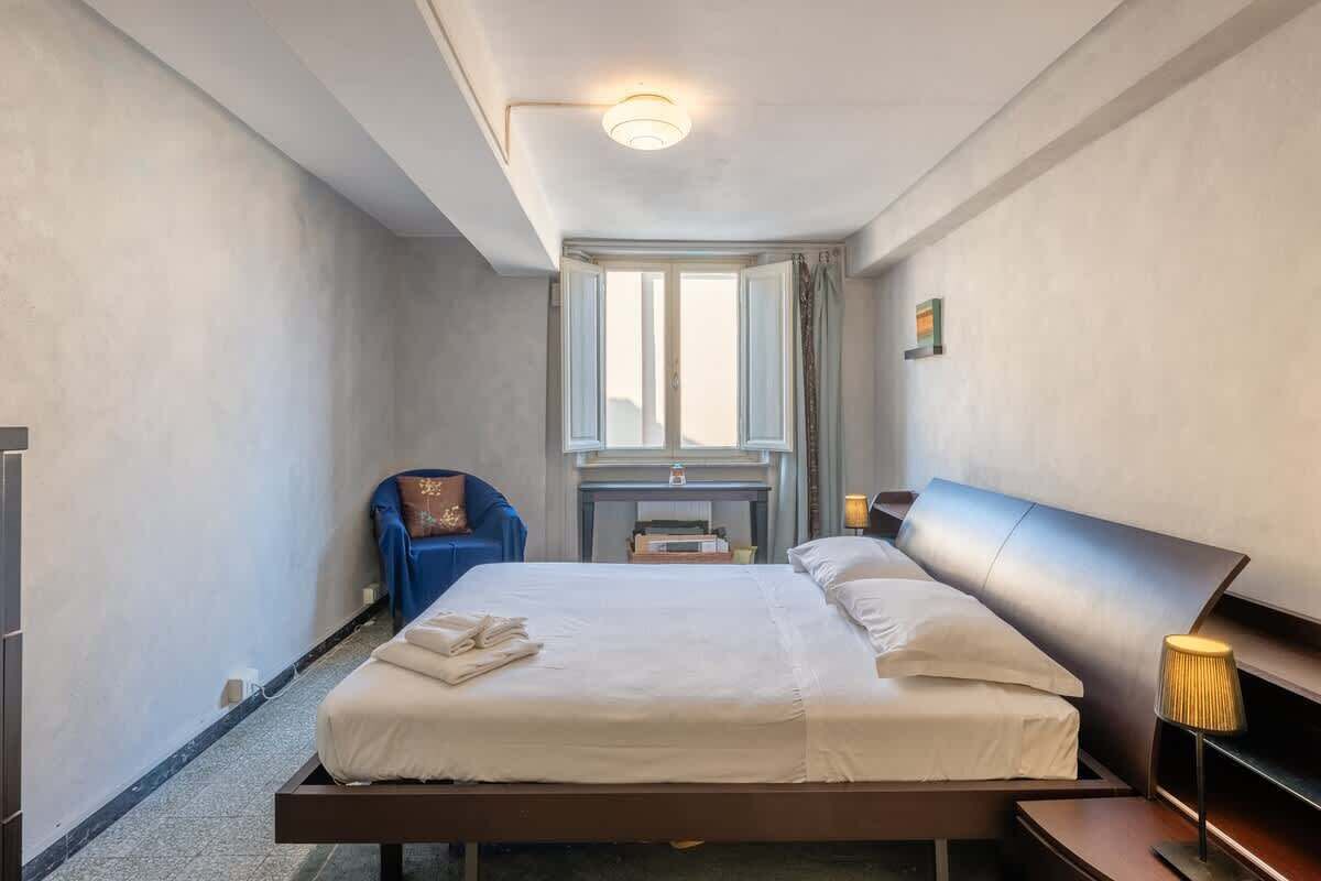 Habitación de hotel con cama, escritorio, silla y ventana.