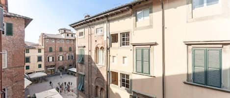 A courtyard with buildings, outdoor seating, and a clear sky.