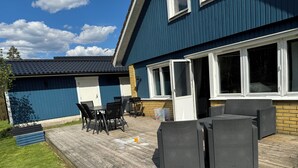A patio with outdoor furniture, a grill, and a covered area with a sliding door. - Modern house for 6 people - close to Gekås Ullared (Hallands län)
