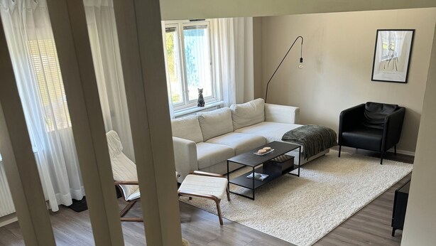 A living room with a sofa, a coffee table, a black armchair, and a white rug. - Modern house for 6 people - close to Gekås Ullared (Hallands län)