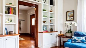 A living room with a blue sofa, white shelving units, and a wooden coffee table. - Red House Paso- Modern Farmhouse Downtown (Paso Robles)