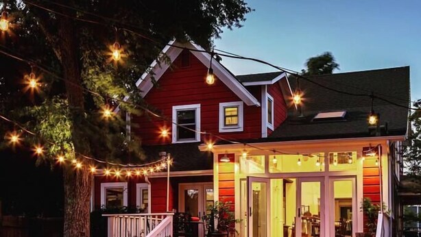 A red house with a porch, outdoor seating, and string lights. - Red House Paso- Modern Farmhouse Downtown (Paso Robles)