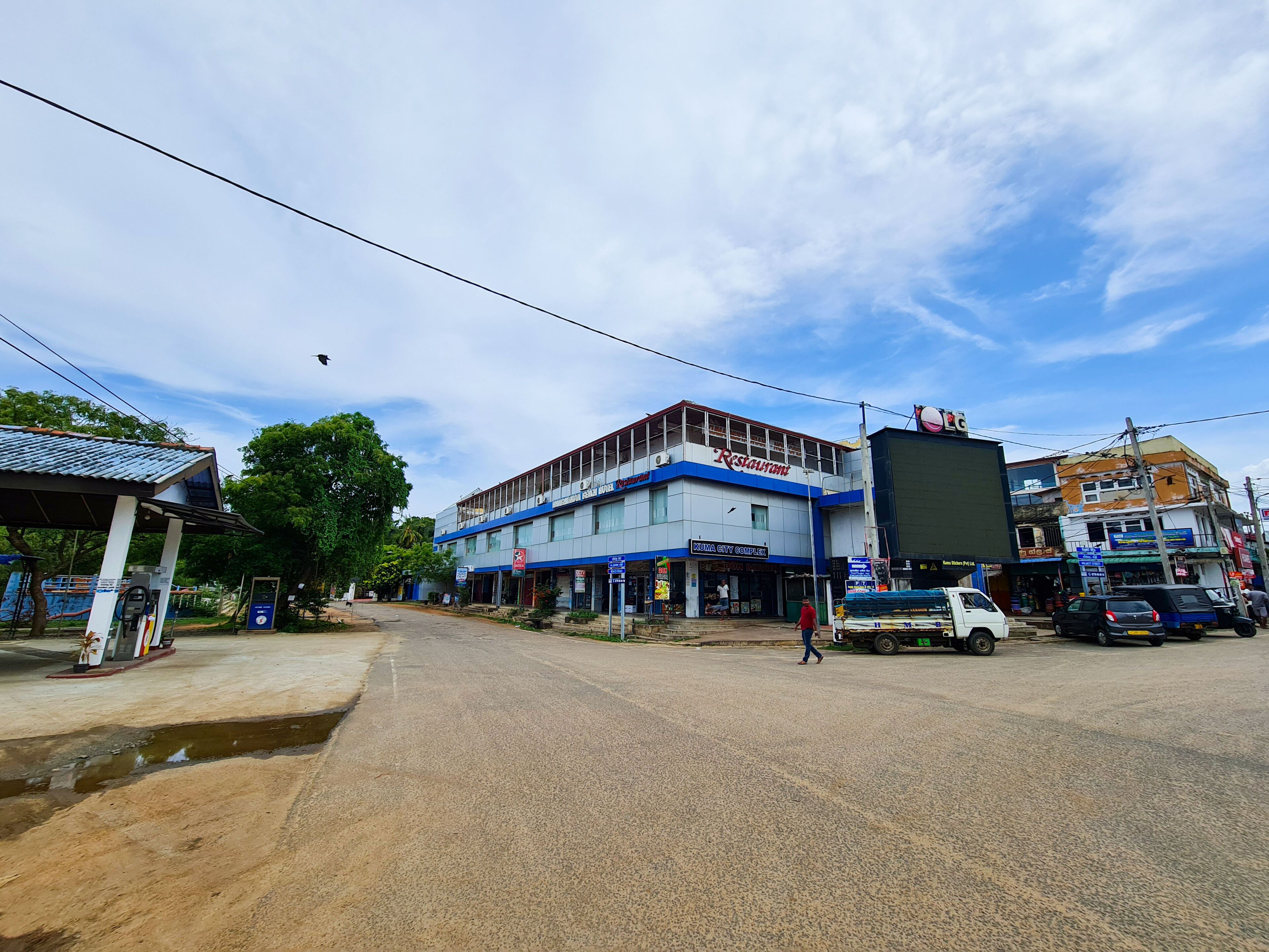 A street view with a building labeled 'Kumina City Complex' and a sign for 'Restaurant'.