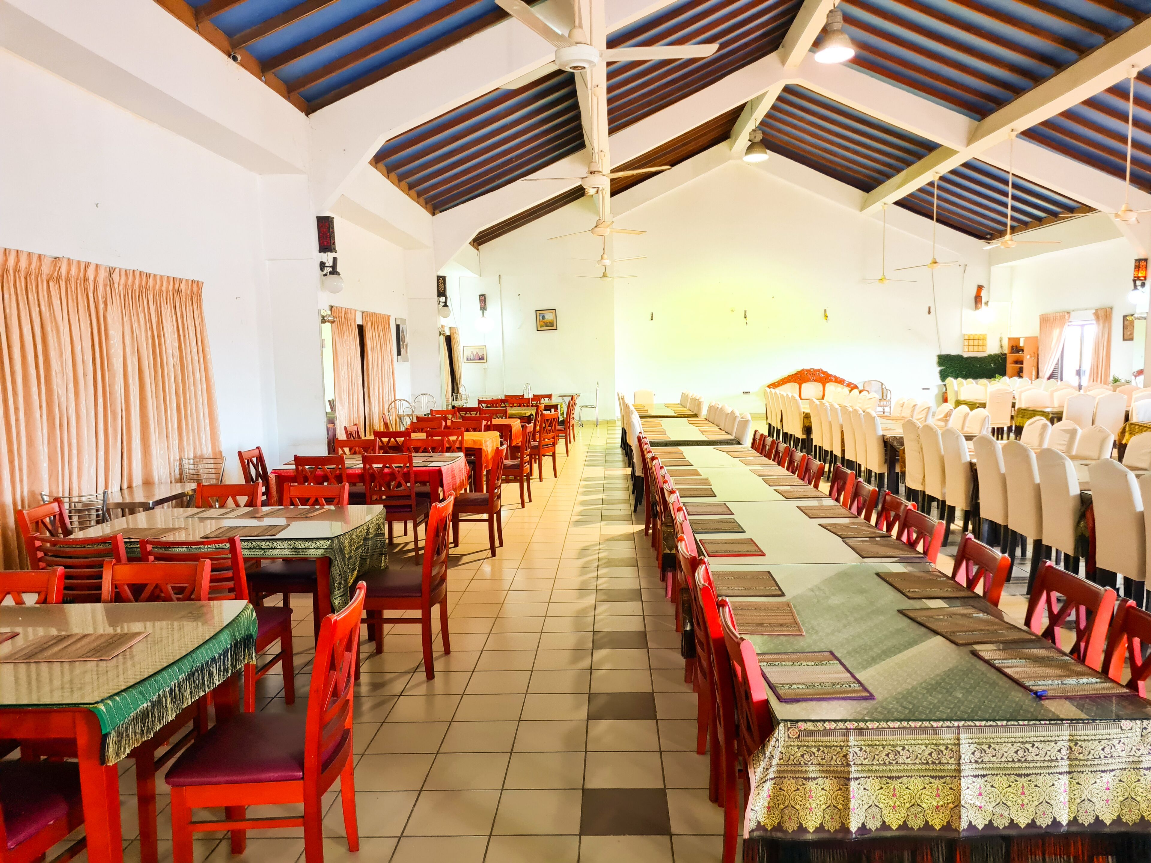 A spacious dining hall with high ceilings and a long table set for a meal.