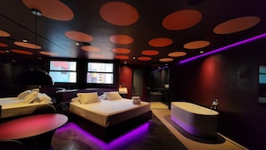 A modern hotel room with a large bed, a desk, and a bathtub. - Andar de Cima (São Paulo)