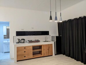 Une cuisine moderne avec un plan de travail blanc, des meubles en bois et une hotte noire.