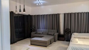 Una habitación de hotel moderna con sofá, reposapiés y cama.