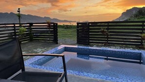 A swimming pool with a tiled edge, surrounded by wooden fences and potted plants. - Villa Overlooking the Bay at Crystal Cove (Sipalay, Negros Occidental)
