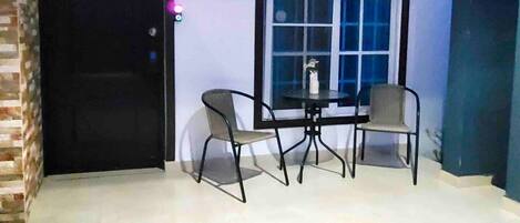 A room with a door, a window, a table, and two chairs.