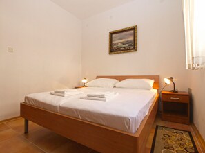 Cozy retreat with a single bed, nightstand, and framed picture.