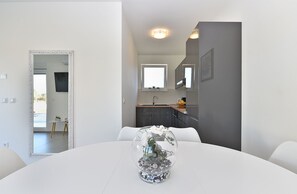Enjoy a meal for two at a beautifully set dining table, surrounded by a stylish mirror and a potted plant.