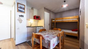 A compact room with a bunk bed, a small kitchenette, a dining table with chairs, and a single bed. - Apt 4 ppl near the ski runs, terrace (Morillon)