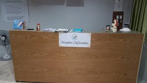 Un comptoir d’accueil avec une pancarte indiquant « Réception/Renseignements ».