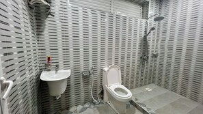 A bathroom with a toilet, sink, and shower.