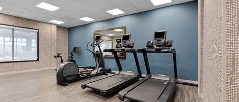 A fitness room with treadmills, an elliptical, and a stationary bike.