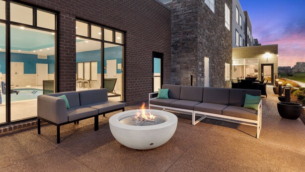 Un espace extérieur aménagé avec un foyer, un canapé et une vue sur la piscine.