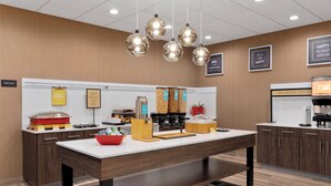 Un buffet pour le petit-déjeuner proposant une variété d’aliments et un espace dédié aux boissons chaudes.