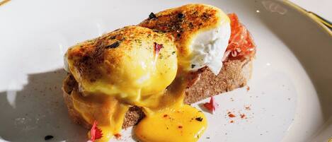 A breakfast dish on a plate with a glass of orange juice in the background.