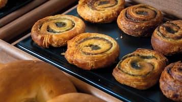 A display of pastries including cinnamon rolls and bagels.