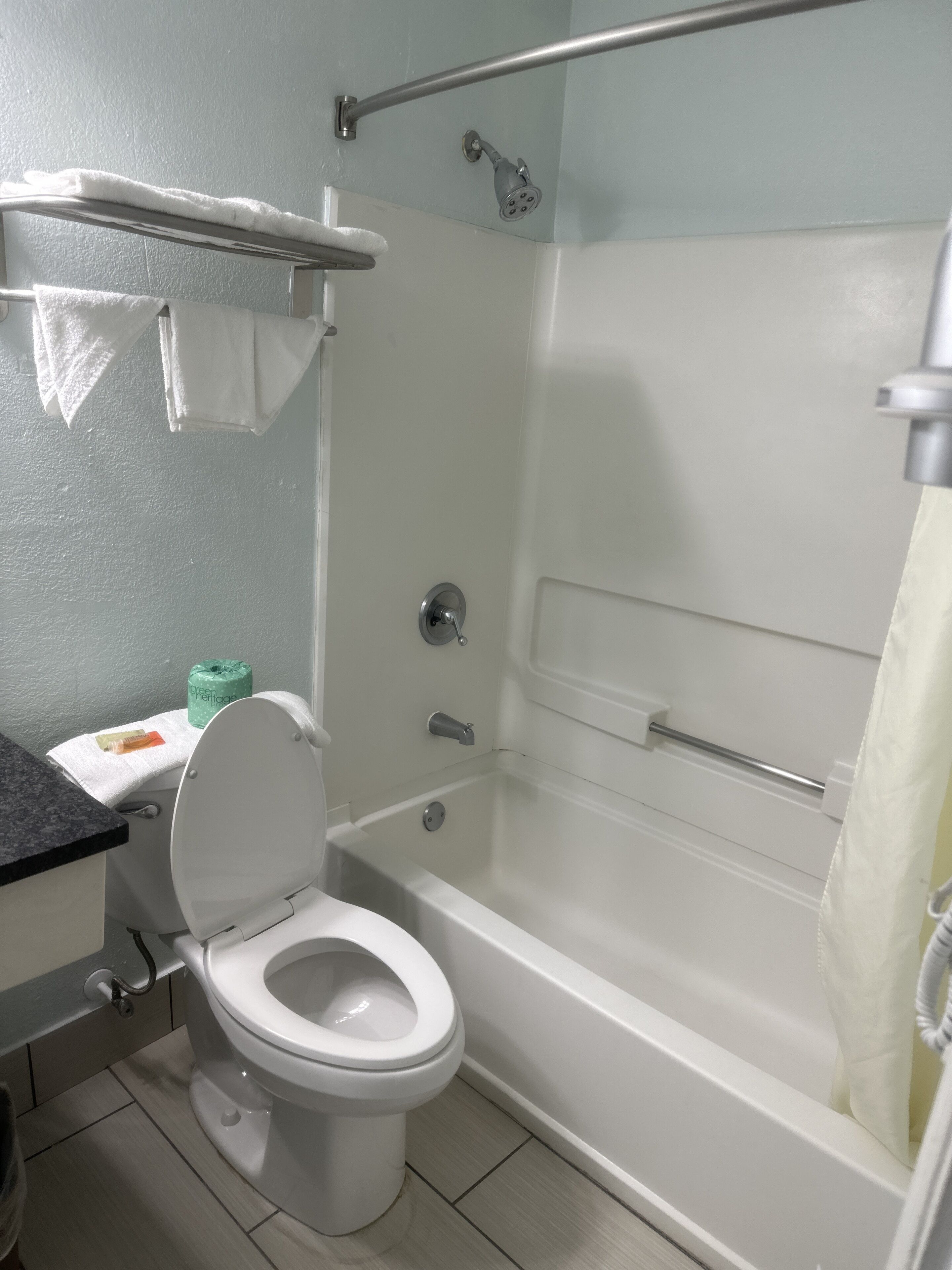 Une salle de bain équipée de toilettes, d’une douche et d’une baignoire.