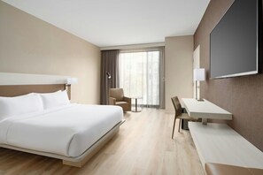 A hotel room with a bed, a desk, a chair, a TV, and a window with curtains. - AC Hotel Jacksonville St Johns Town Center (Jacksonville)
