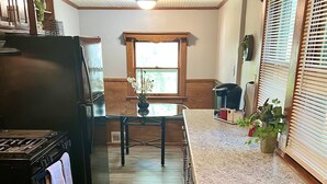 Una cocina con estufa, refrigerador y ventana.
