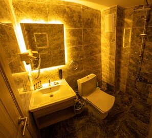 Kylpyhuone, jossa on pesuallas, wc ja suihku.