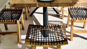 Een eettafel met zes stoelen, een vaas en zes wijnglazen, gedekt voor zes personen.