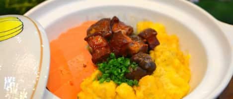 A bowl of food with a side dish and a cup.
